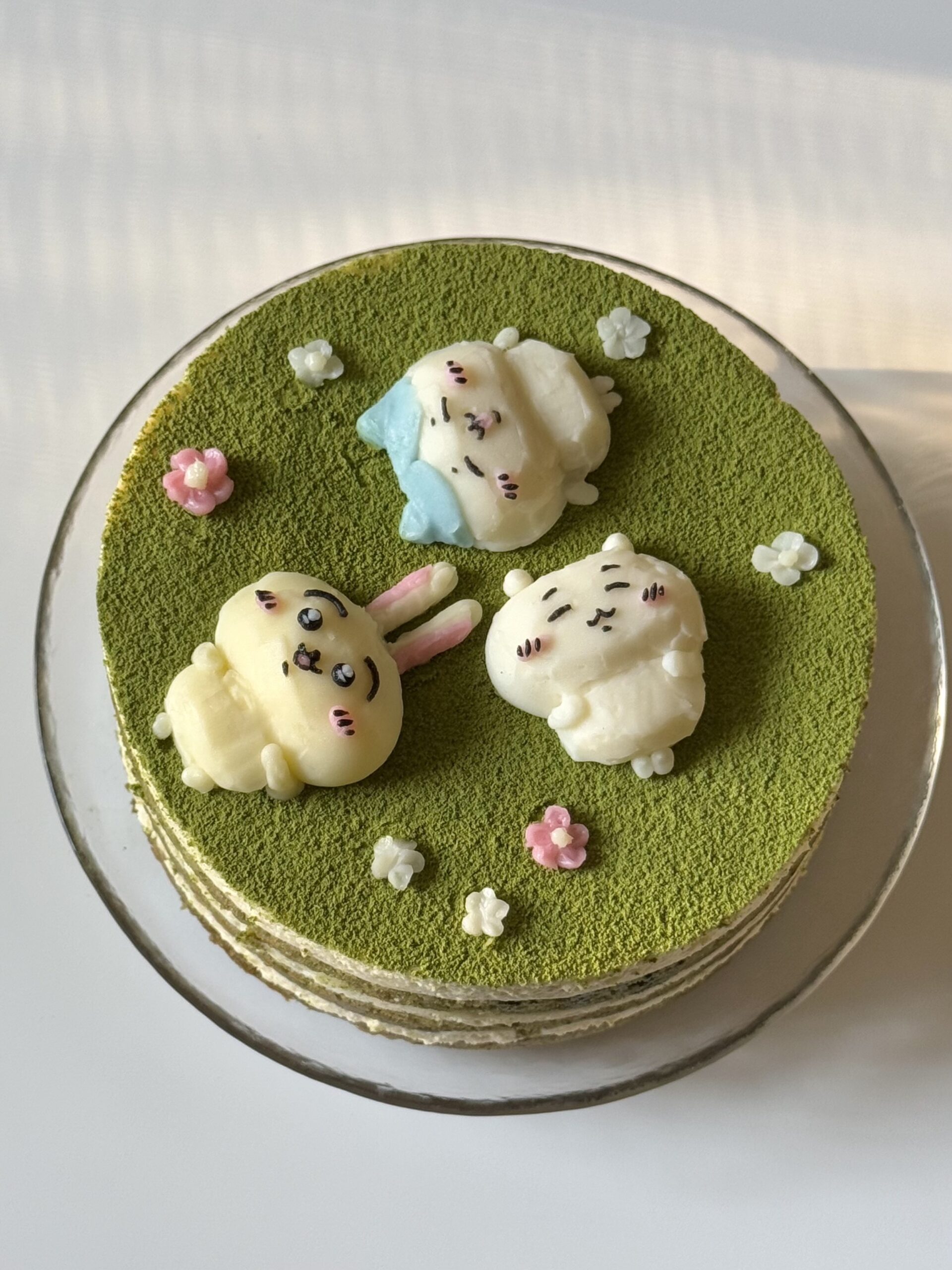 matcha tiramisu cake decorated with little characters to depict scene of lying down in grass